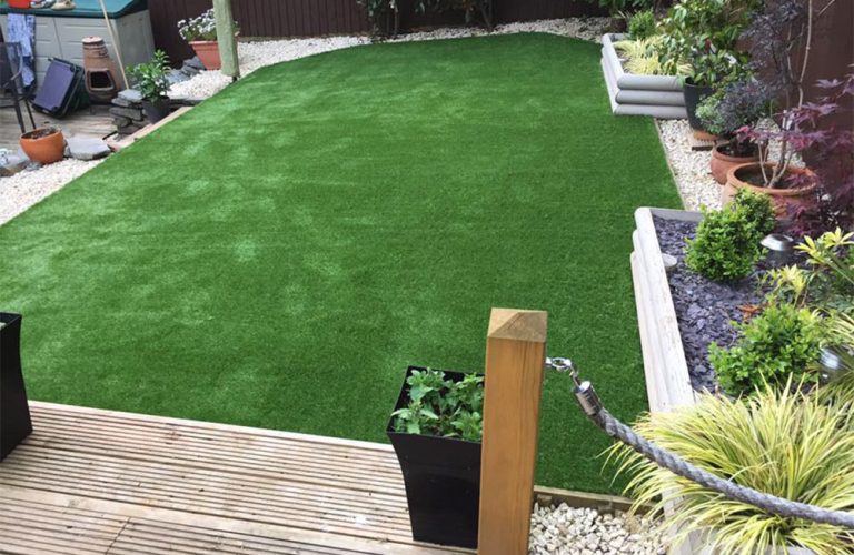Finished grass next to decking in a back garden